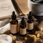 Huiles essentielles hélichryse pour bleus, circulation et peau : fioles et pétales sur table